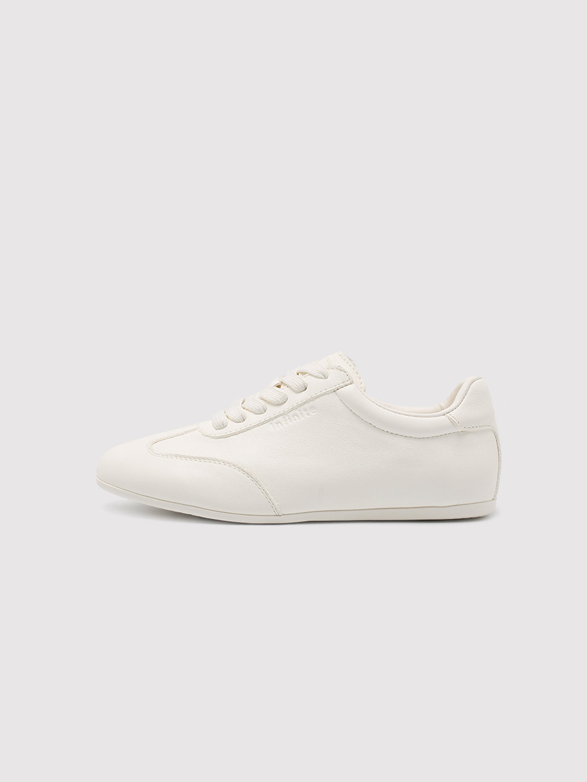 Side view of women's white leather low-profile sneakers