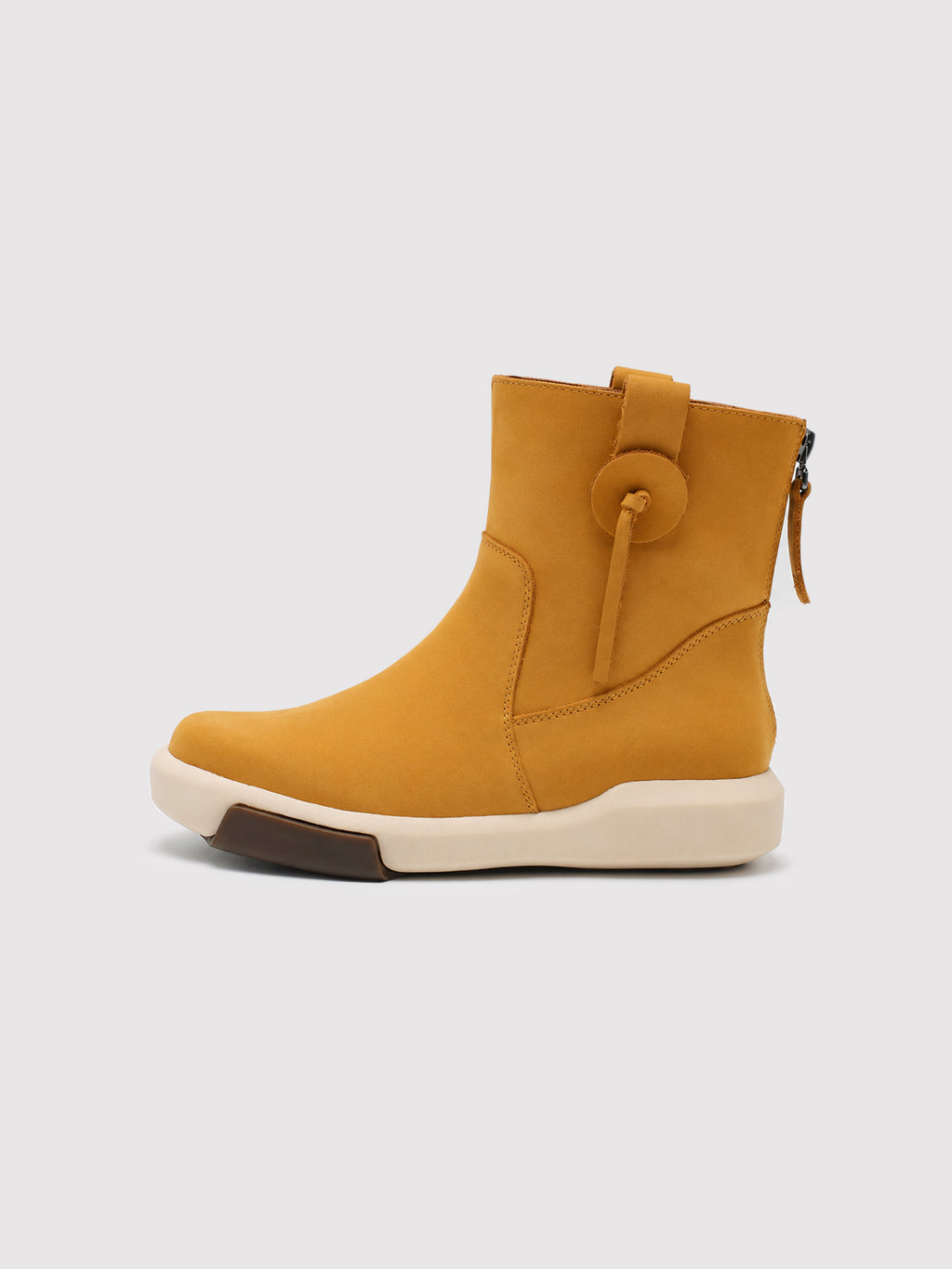 Yellow suede ankle boot shown from the opposite side, with a decorative loop, rounded toe and cream sole.